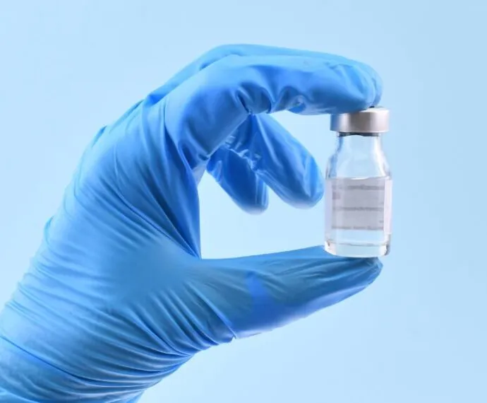 healthcare professional holding treatment vial